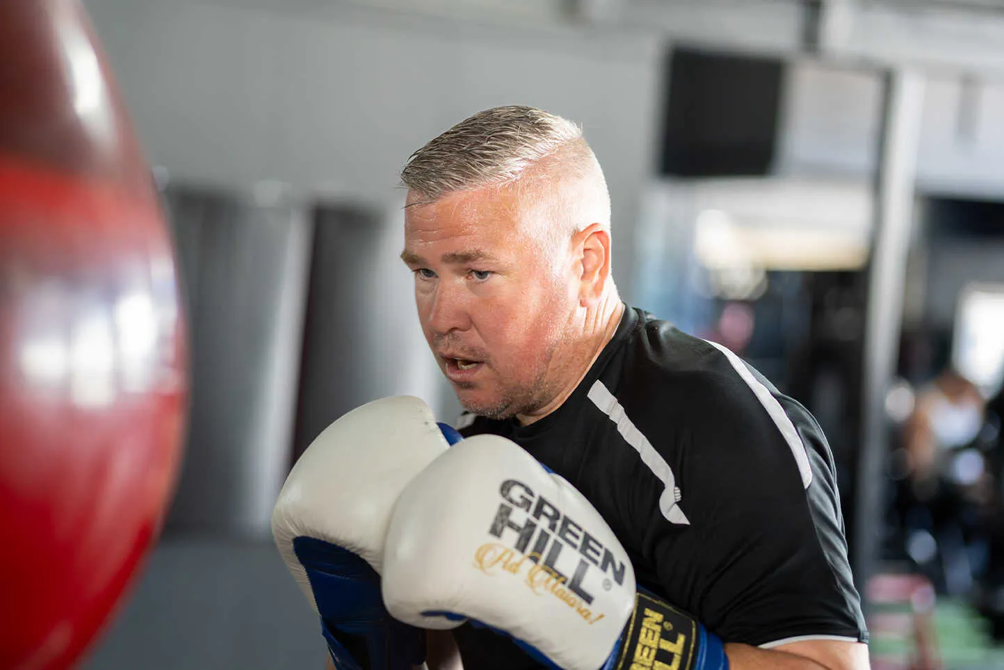Trainer begeleidt sporter tijdens de bokszaktraining bij BOKS Gouda